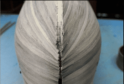 Genforsegling af planker på stævnen af et modelskib med bluffbue 1